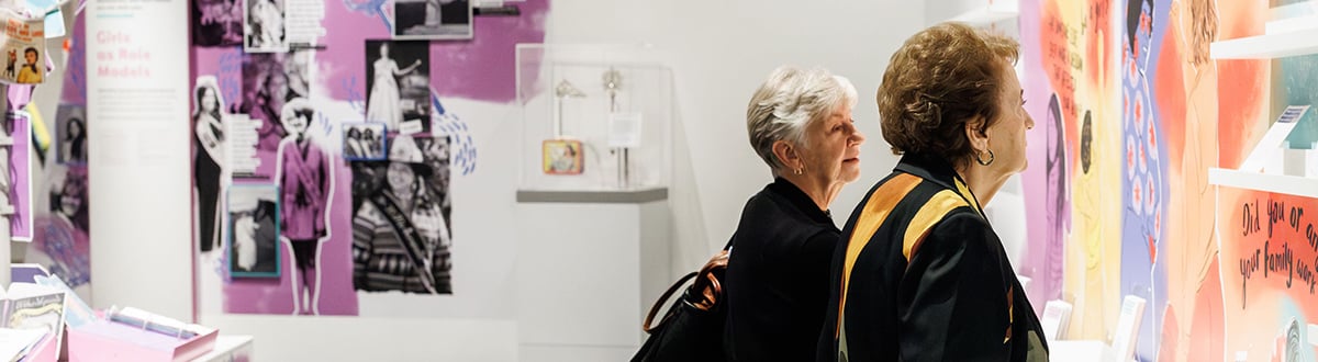 Two women look through an exhibit.